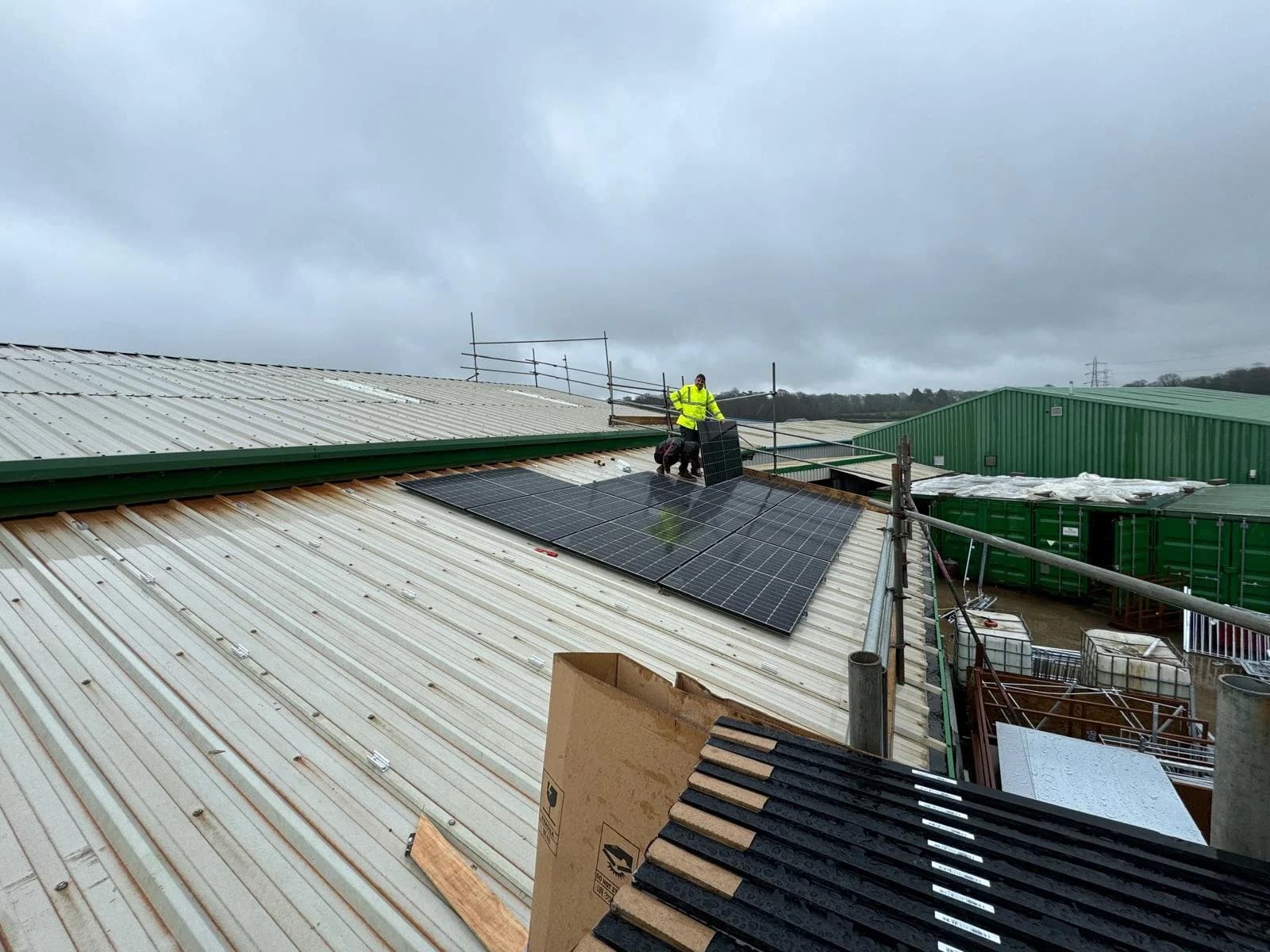 An installer fitting solar panels on the workshop’s metal roof