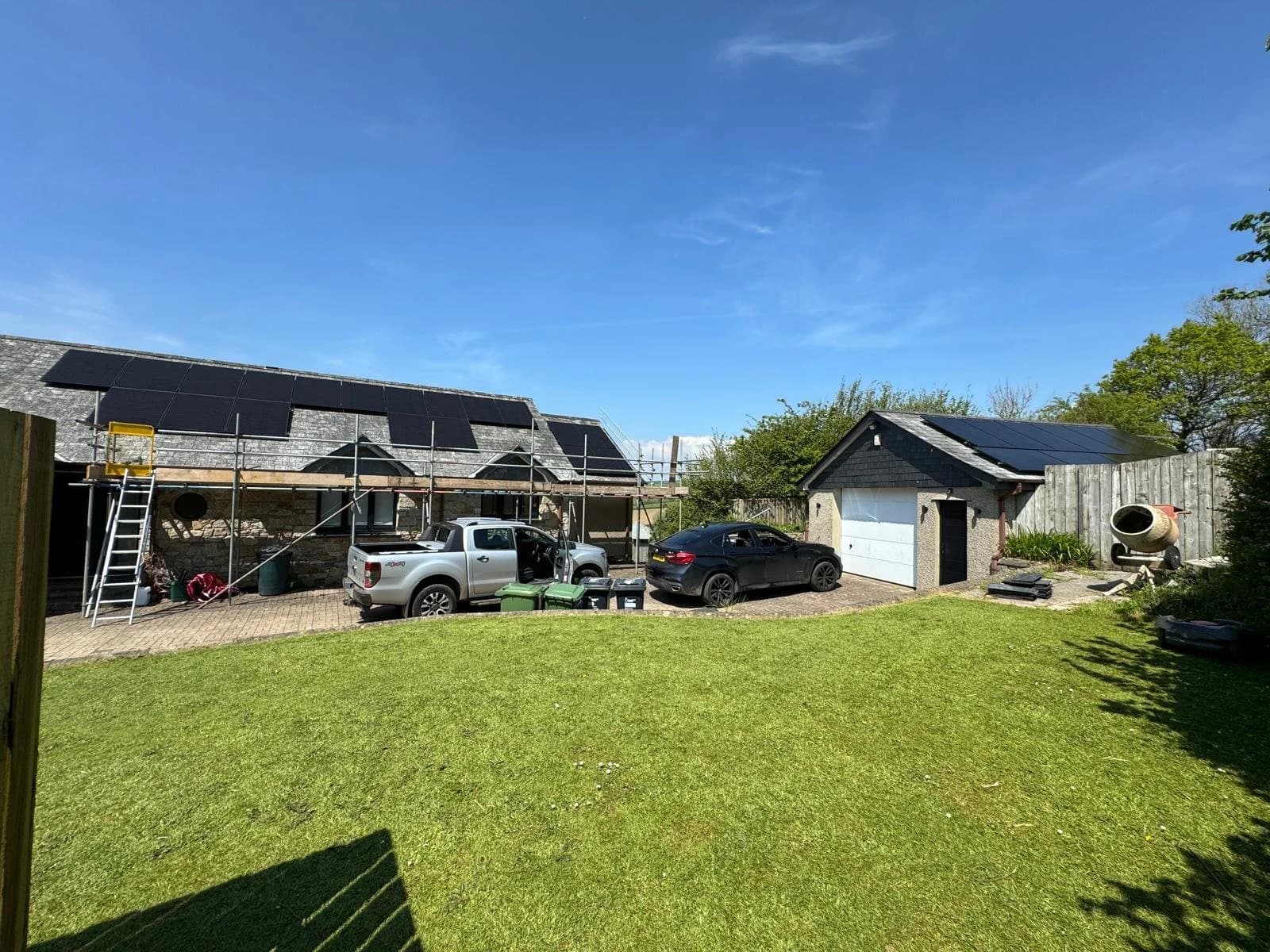 A stone farmhouse at Dolcoath, Pillaton, with solar panels on the roof and the lawn in front